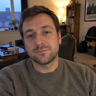 Portrait of Rory Calder, a man in his thirties with short hair and a grey jumper